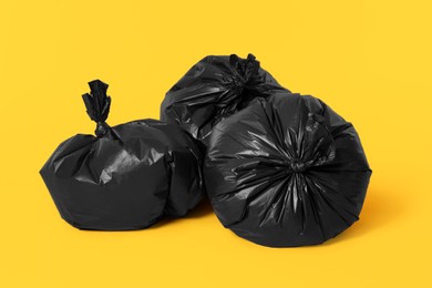 Photo of Trash bags full of garbage on orange background