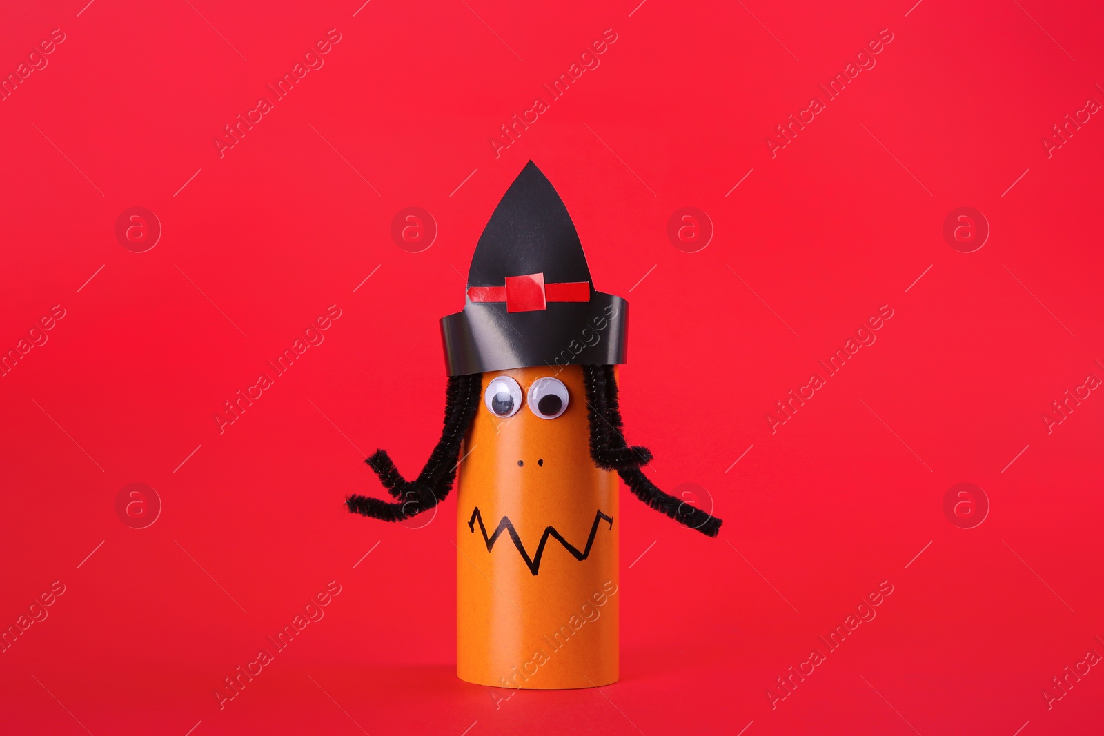 Photo of Funny orange monster on red background. Halloween decoration
