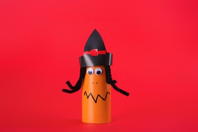 Funny orange monster on red background. Halloween decoration