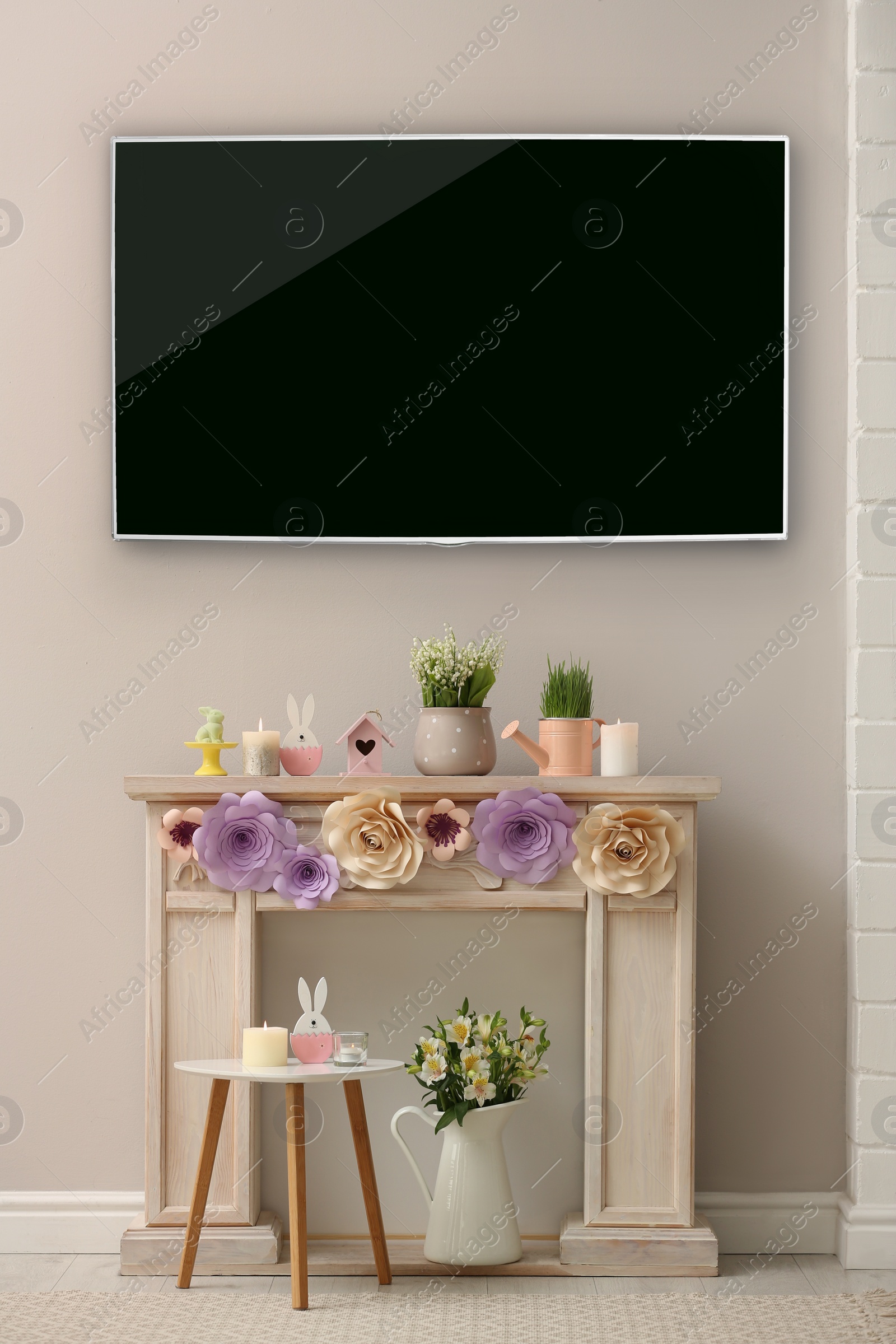 Image of Modern wide screen TV and decorative fireplace with beautiful spring decor in room