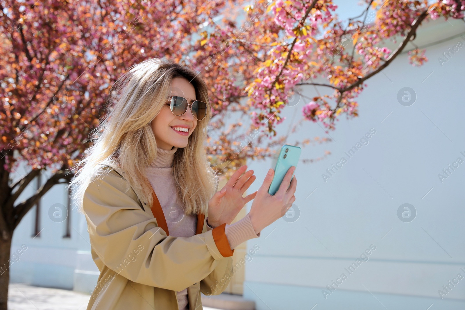 Photo of Young woman taking selfie on city street