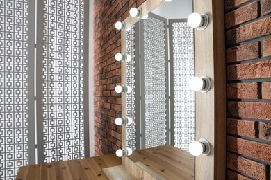 Makeup room interior with wooden table and large mirror