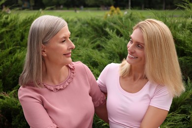 Happy mature mother and her daughter outdoors