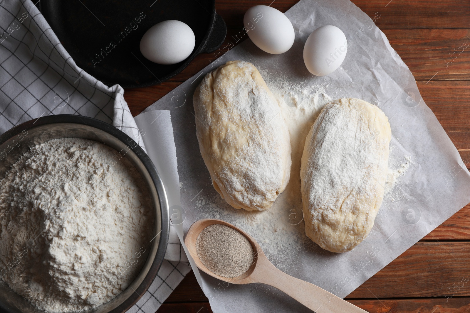 Photo of Raw dough, eggs and flour on wooden table, flat lay. Cooking ciabatta