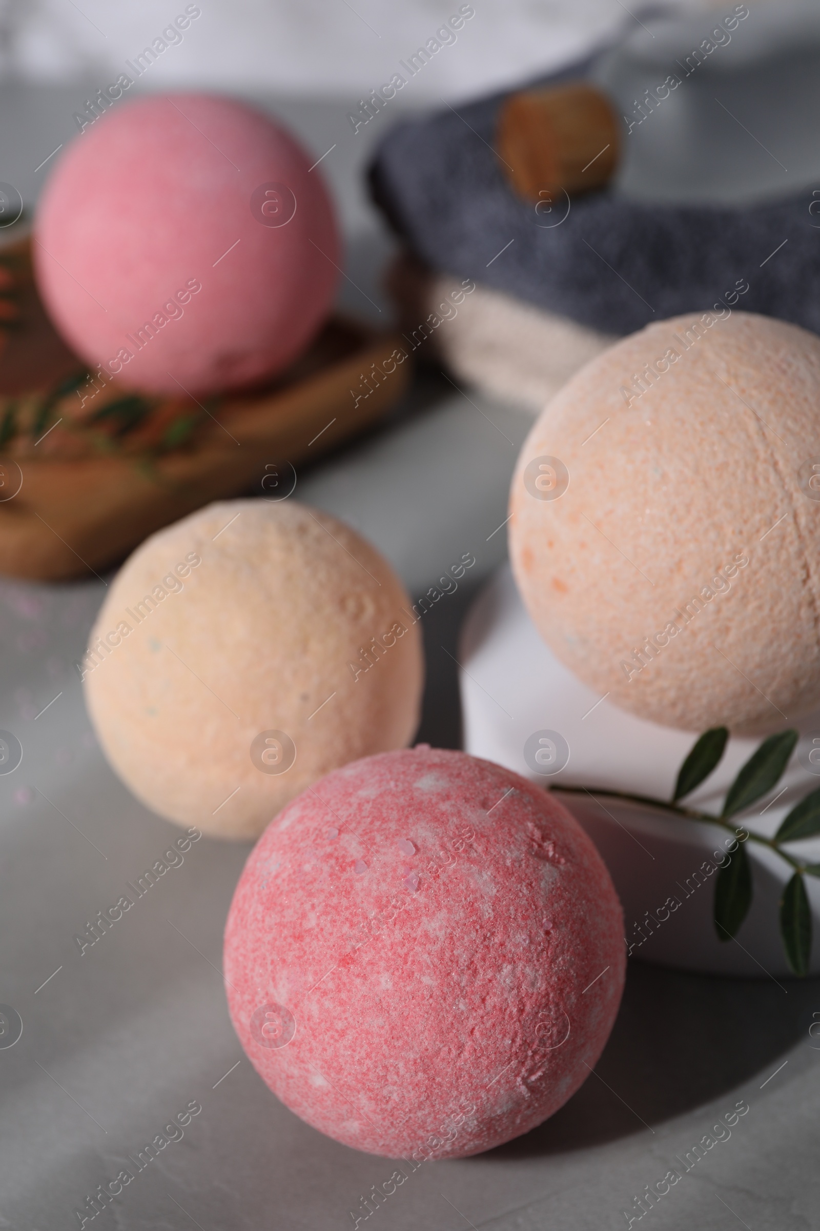 Photo of Beautiful aromatic bath bombs and green twig on grey table