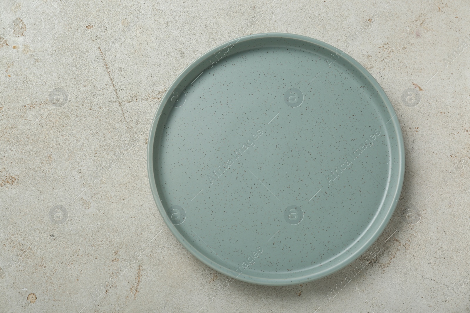 Photo of Empty ceramic plate on light grey table, top view. Space for text