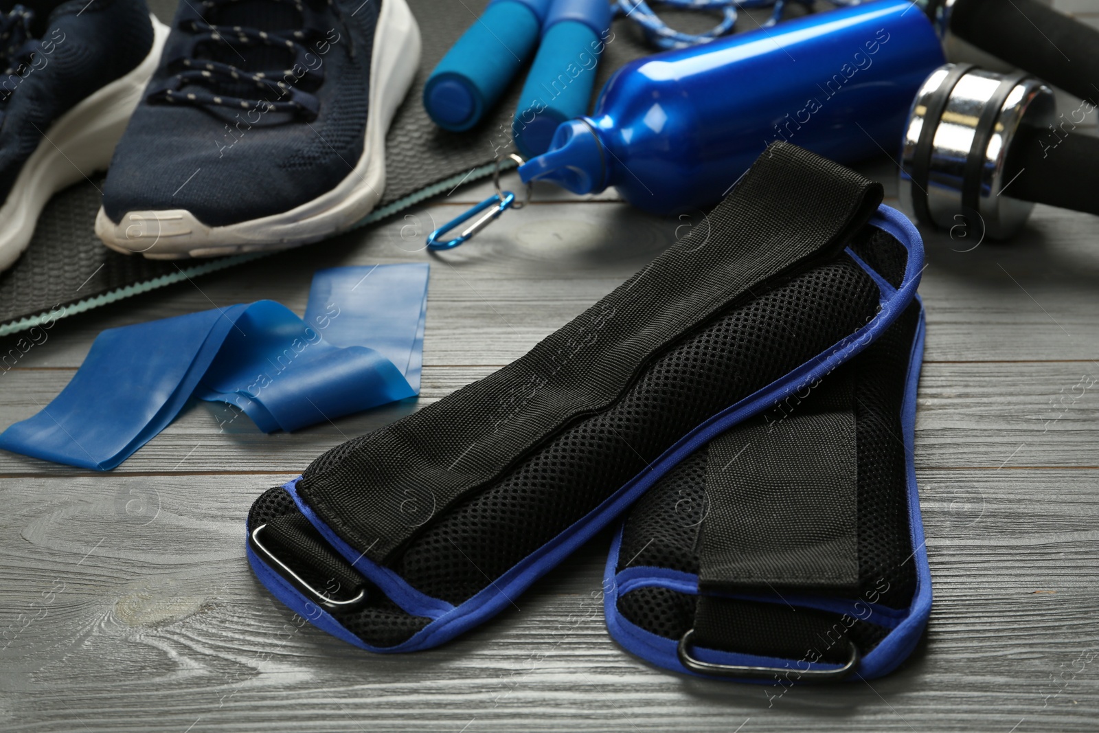 Photo of Blue weighting agents and sport equipment on grey wooden table