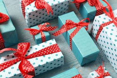 Photo of Christmas gift boxes with red bows on grey wooden background