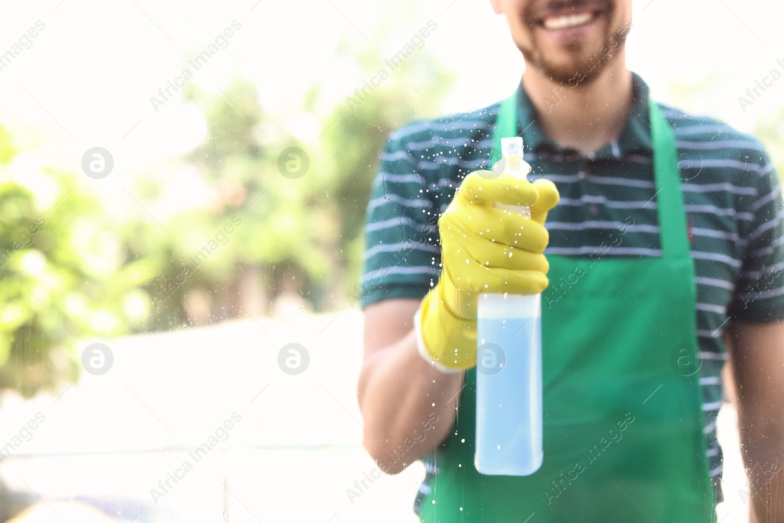 Photo of Male worker washing window glass from outside