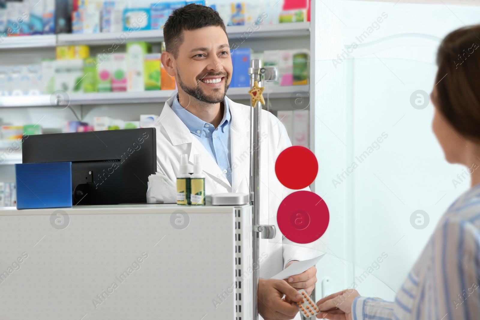 Photo of Professional pharmacist giving pills to customer in drugstore