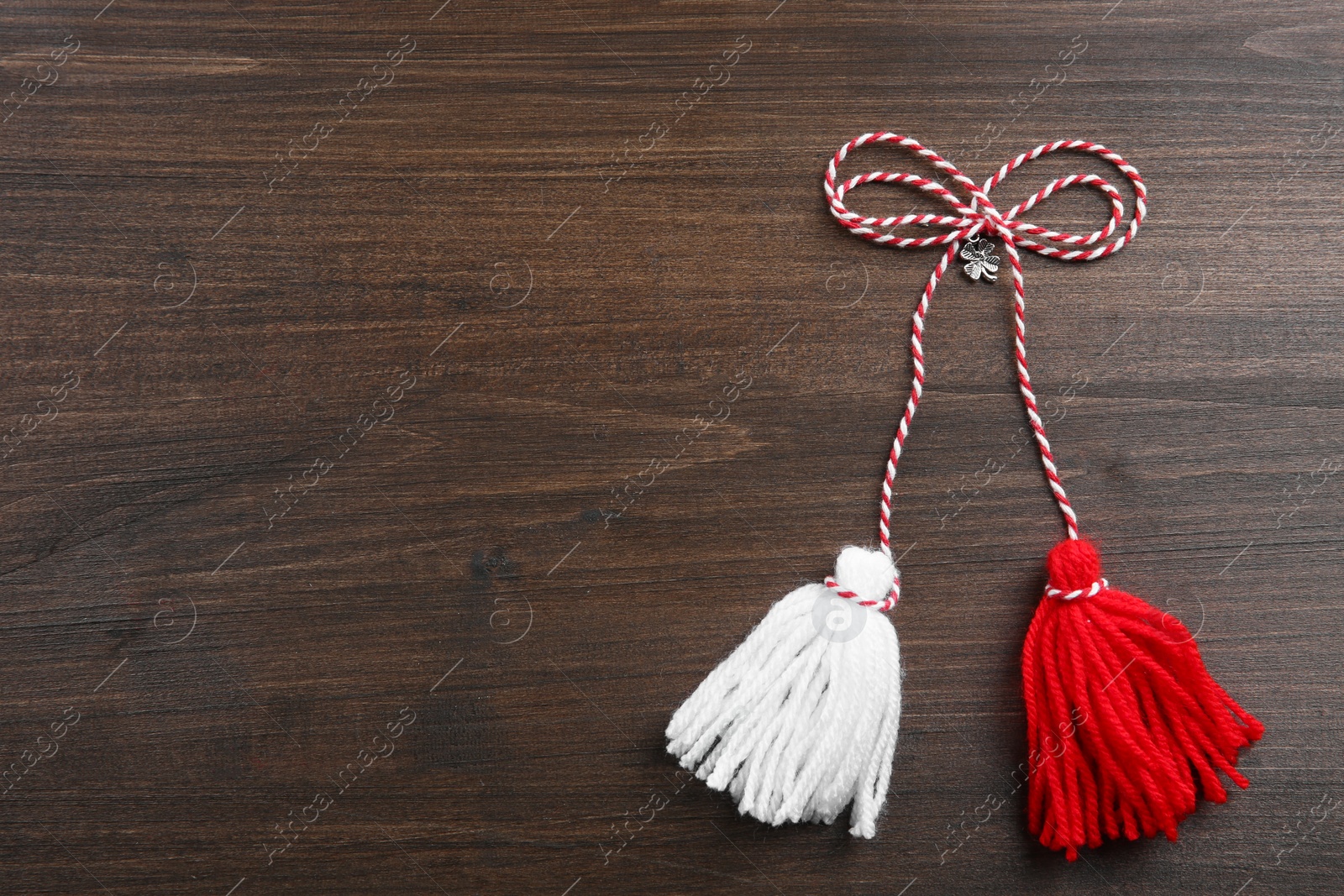 Photo of Traditional martisor on wooden background, top view with space for text. Beginning of spring celebration