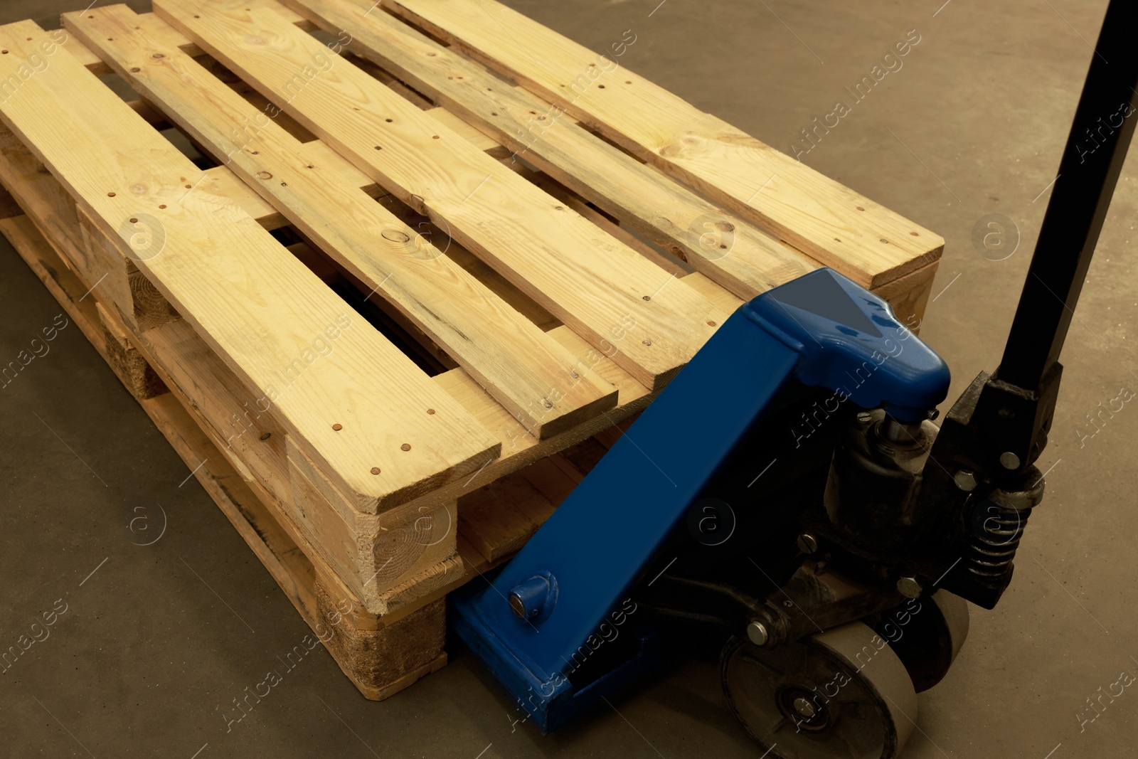 Image of Modern manual forklift with wooden pallets in warehouse, closeup