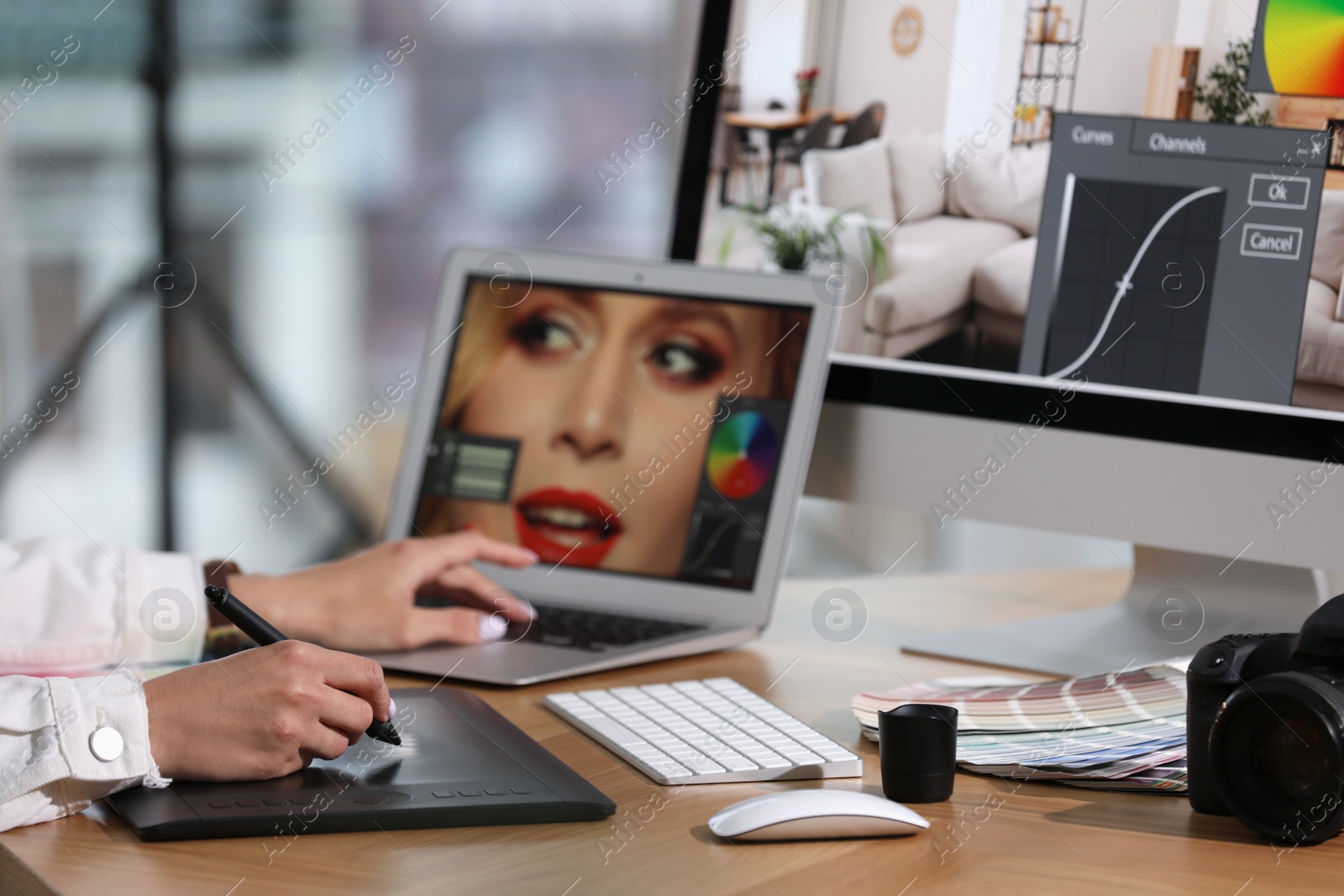 Photo of Professional retoucher working on graphic tablet and laptop at table, closeup