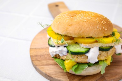 Photo of Tasty vegan burger with vegetables, sauce and patty on white background, closeup