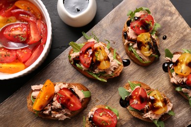Photo of Delicious bruschettas with balsamic vinegar, tomatoes, arugula and tuna on grey textured table, flat lay