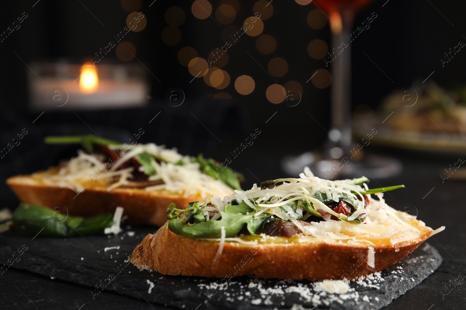 Photo of Delicious bruschettas with beef and cheese on black table, closeup
