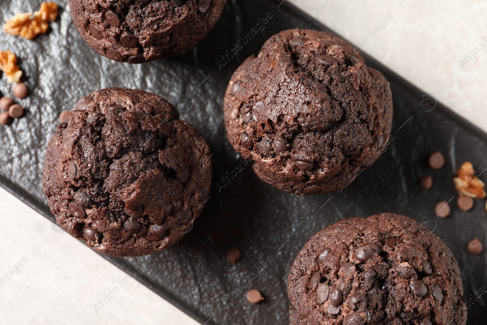 Photo of Delicious chocolate muffins on light table, top view