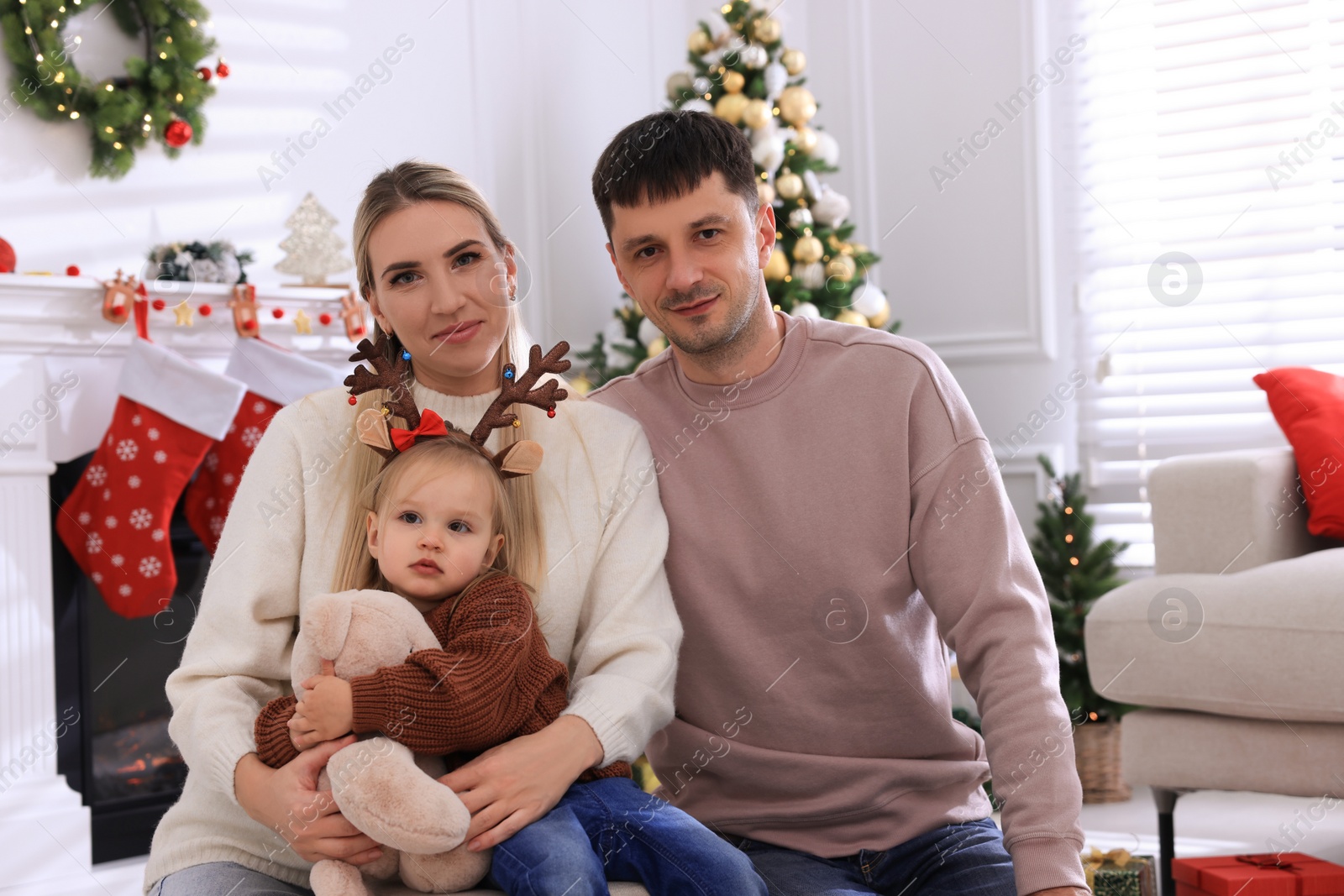Photo of Happy family in room decorated for Christmas