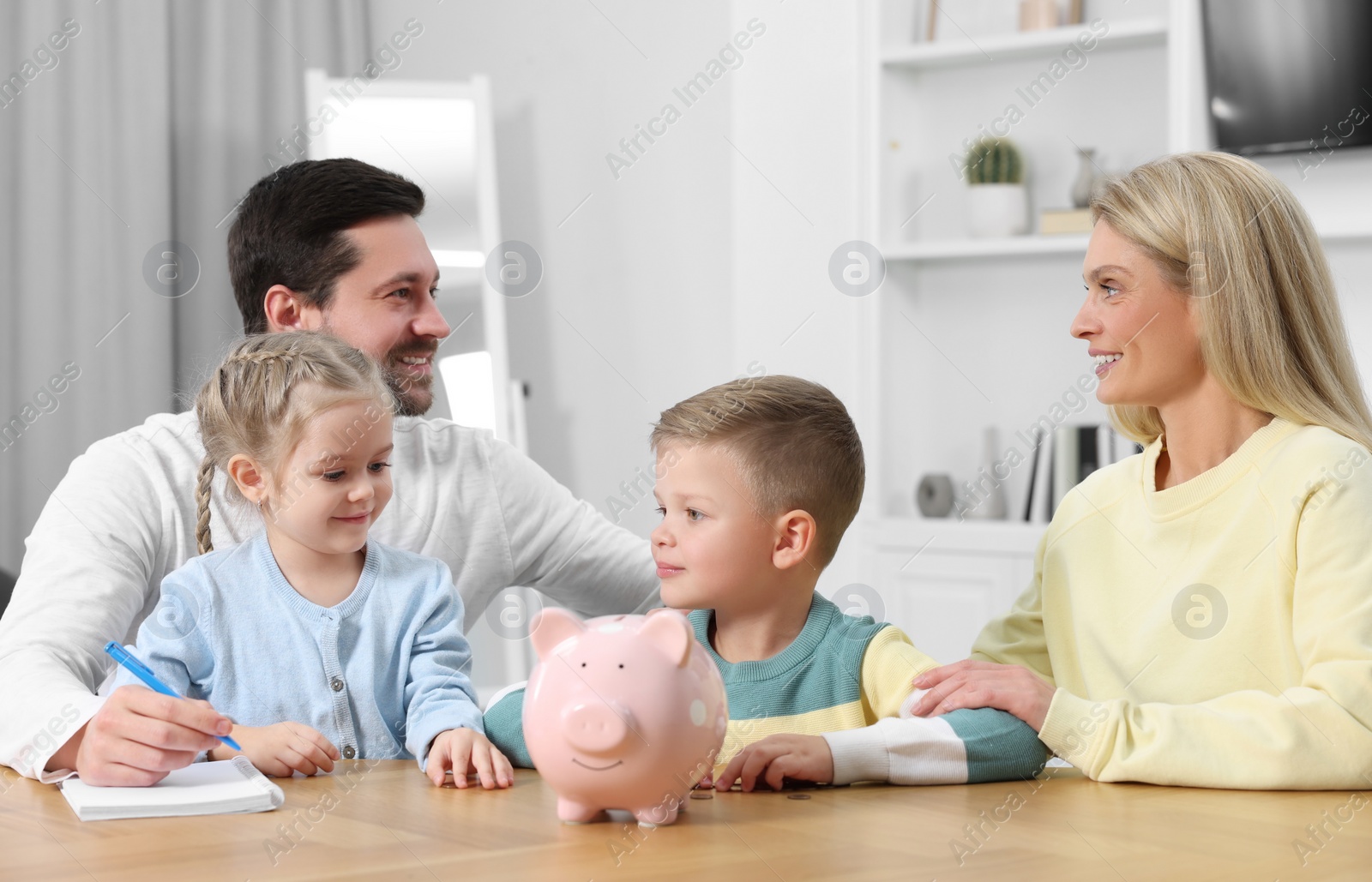 Photo of Planning budget together. Family with piggy bank and coins at home