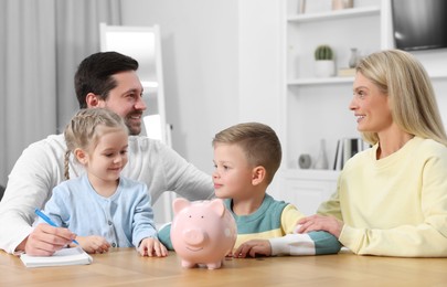 Planning budget together. Family with piggy bank and coins at home