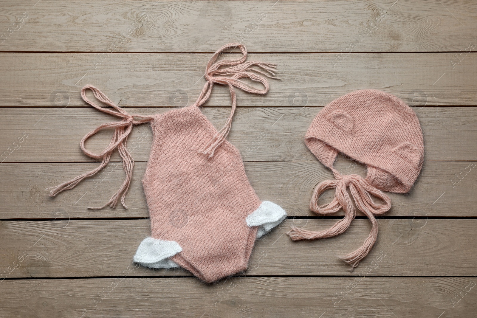 Photo of Set of cute baby knitwear for photoshoot on wooden background, flat lay