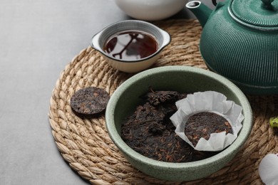 Photo of Composition with aromatic pu-erh tea on light grey table, closeup