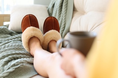 Photo of Woman wearing soft comfortable slippers at home, closeup