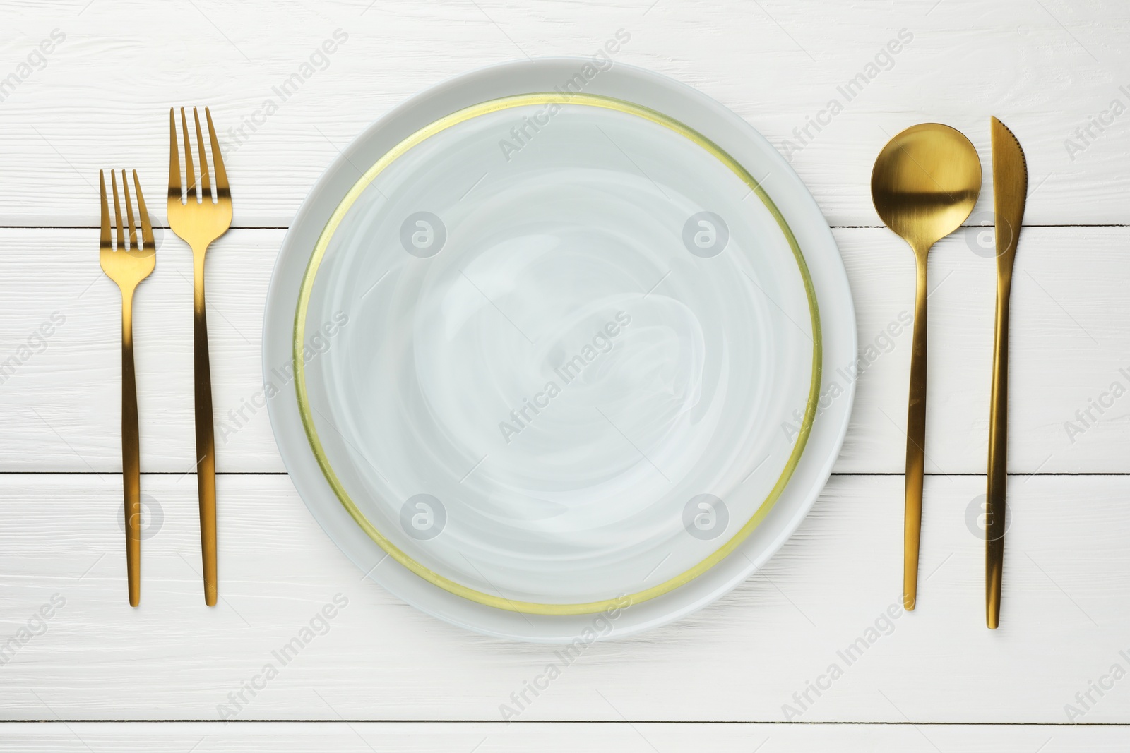 Photo of Stylish setting with cutlery and plate on white wooden table, flat lay