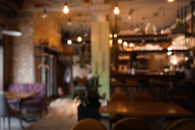 Photo of Blurred view of stylish modern cafe interior with bokeh effect