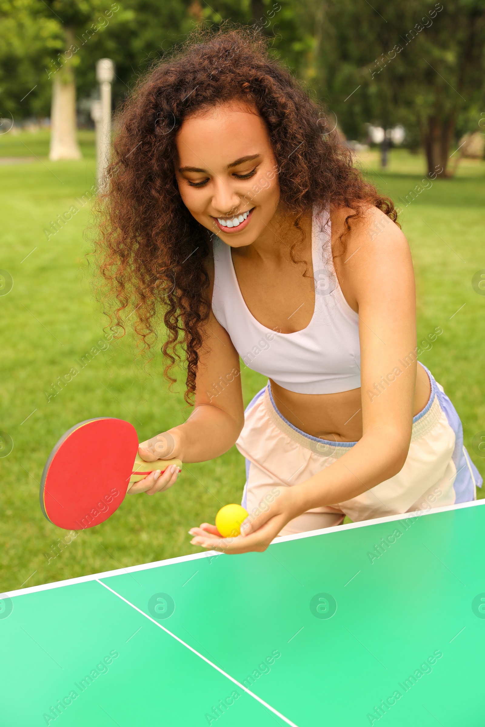 Photo of Young African-American woman playing ping pong outdoors