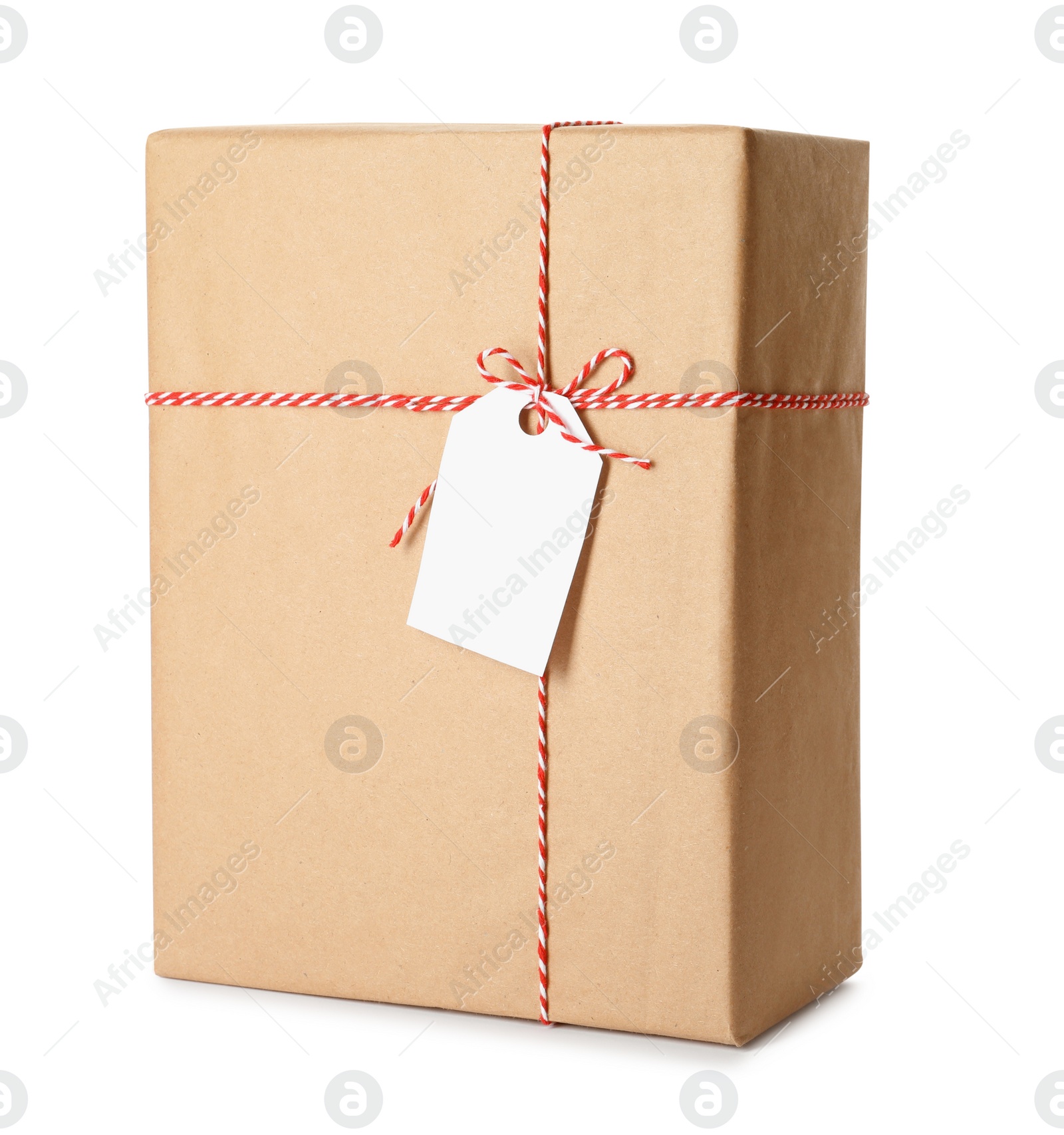 Photo of Gift box wrapped in kraft paper with bow and tag isolated on white