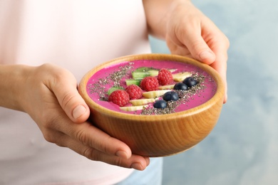 Photo of Woman holding bowl of acai smoothie with chia seeds, closeup