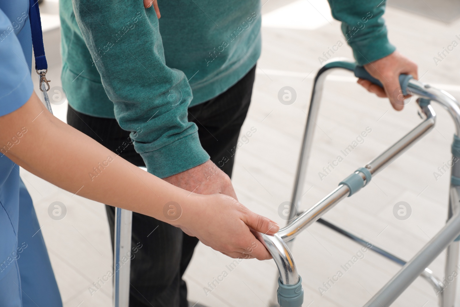 Photo of Nurse assisting senior man with walker in hospital, closeup