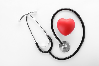 Stethoscope and red heart on white background, top view