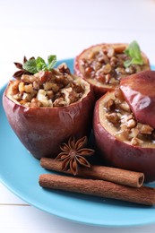 Photo of Tasty baked apples with nuts, honey, spices and mint on white wooden table, closeup