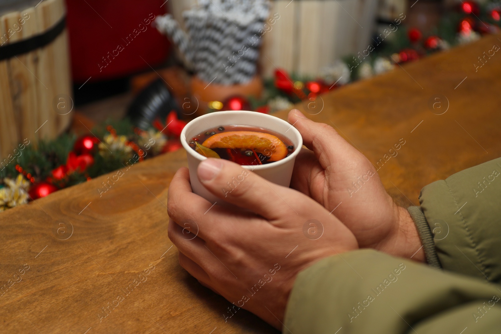 Photo of Man with cup of mulled wine at counter, closeup