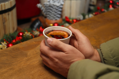 Man with cup of mulled wine at counter, closeup
