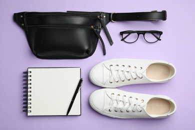 Flat lay composition with stylish woman's bag and accessories on violet background