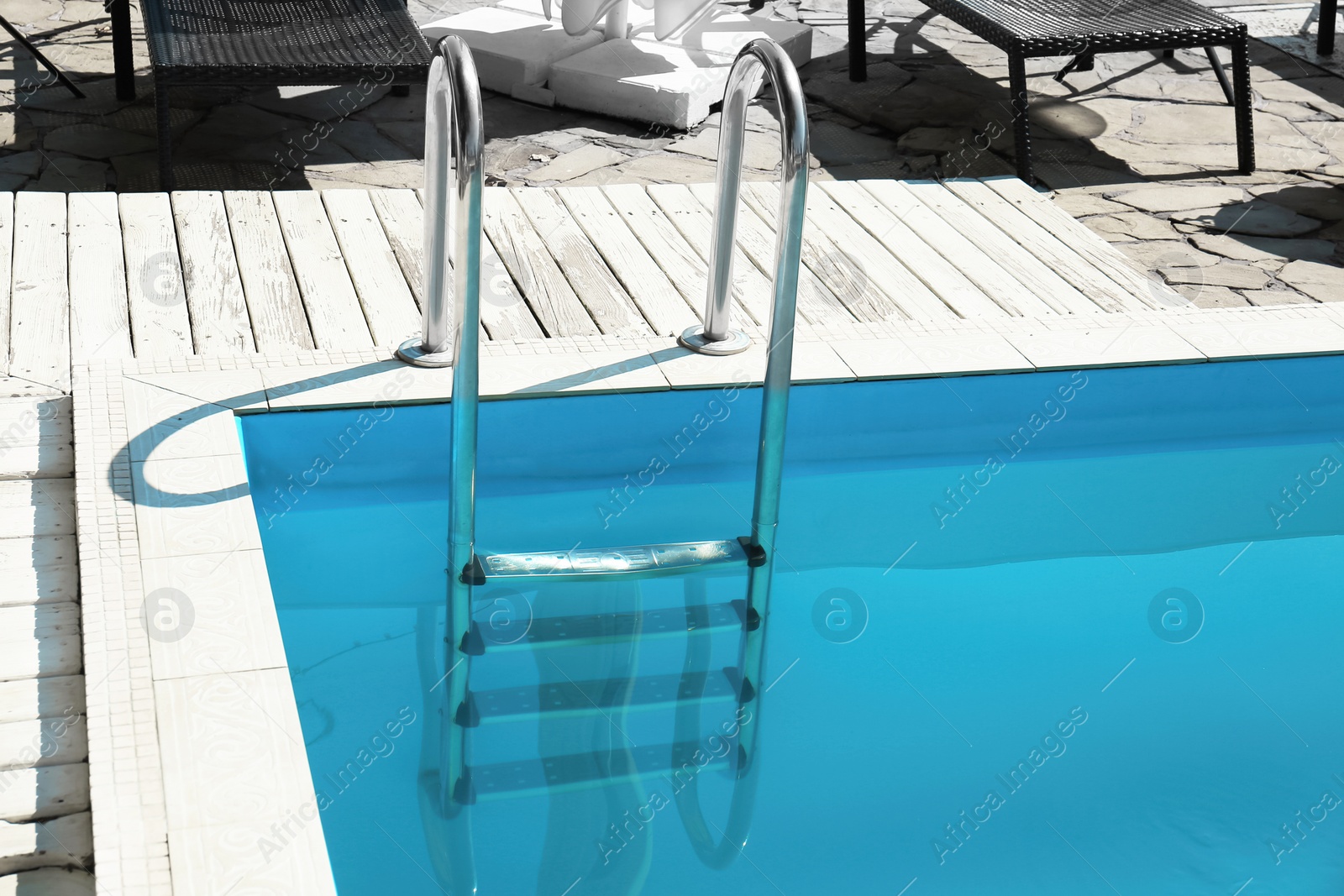 Photo of Modern swimming pool with step ladder outdoors