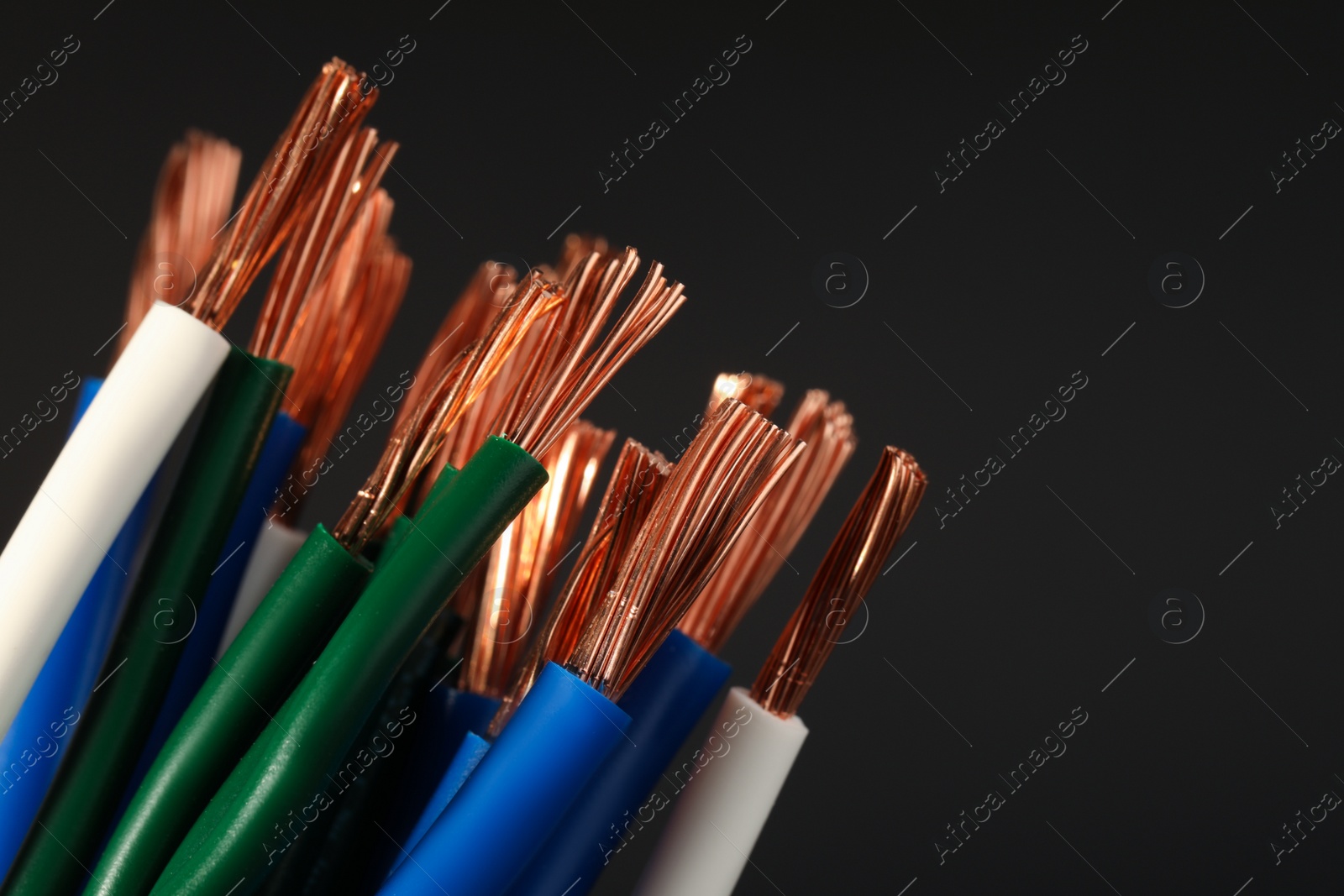 Photo of Electrical wires on black background, closeup. Space for text