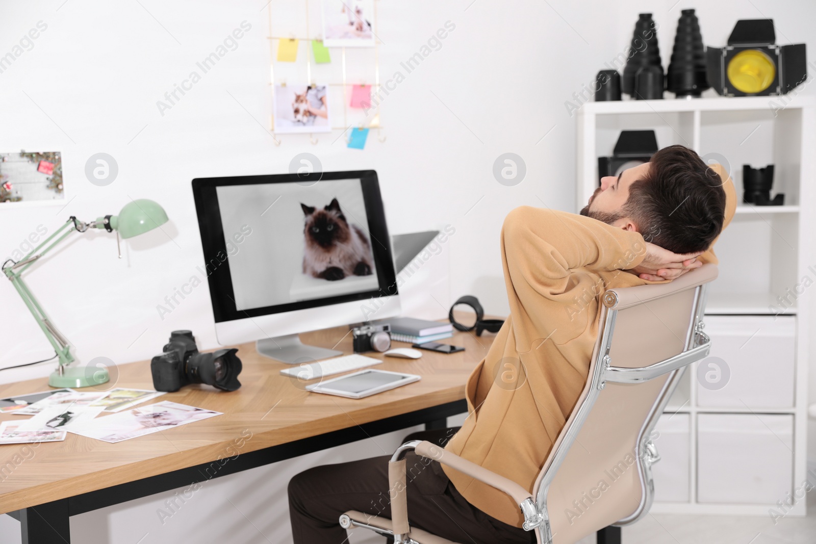 Photo of Professional photographer resting at workplace in office