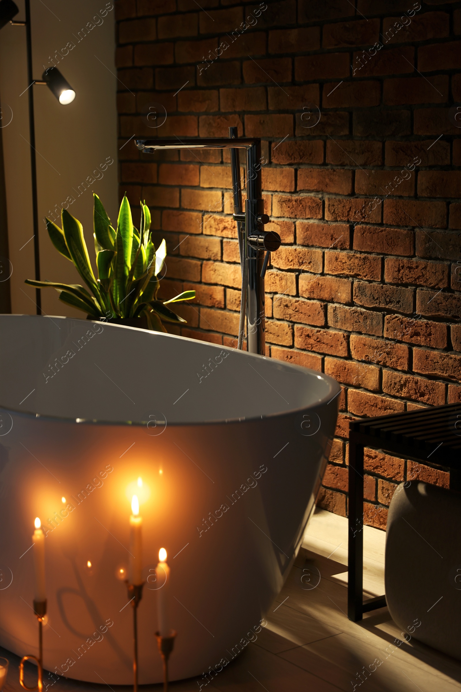 Photo of Stylish bathroom interior with ceramic tub and burning candles