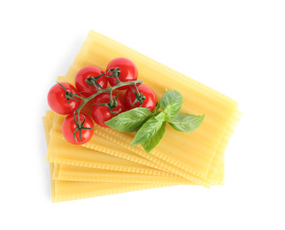 Uncooked lasagna sheets, cherry tomatoes and basil isolated on white