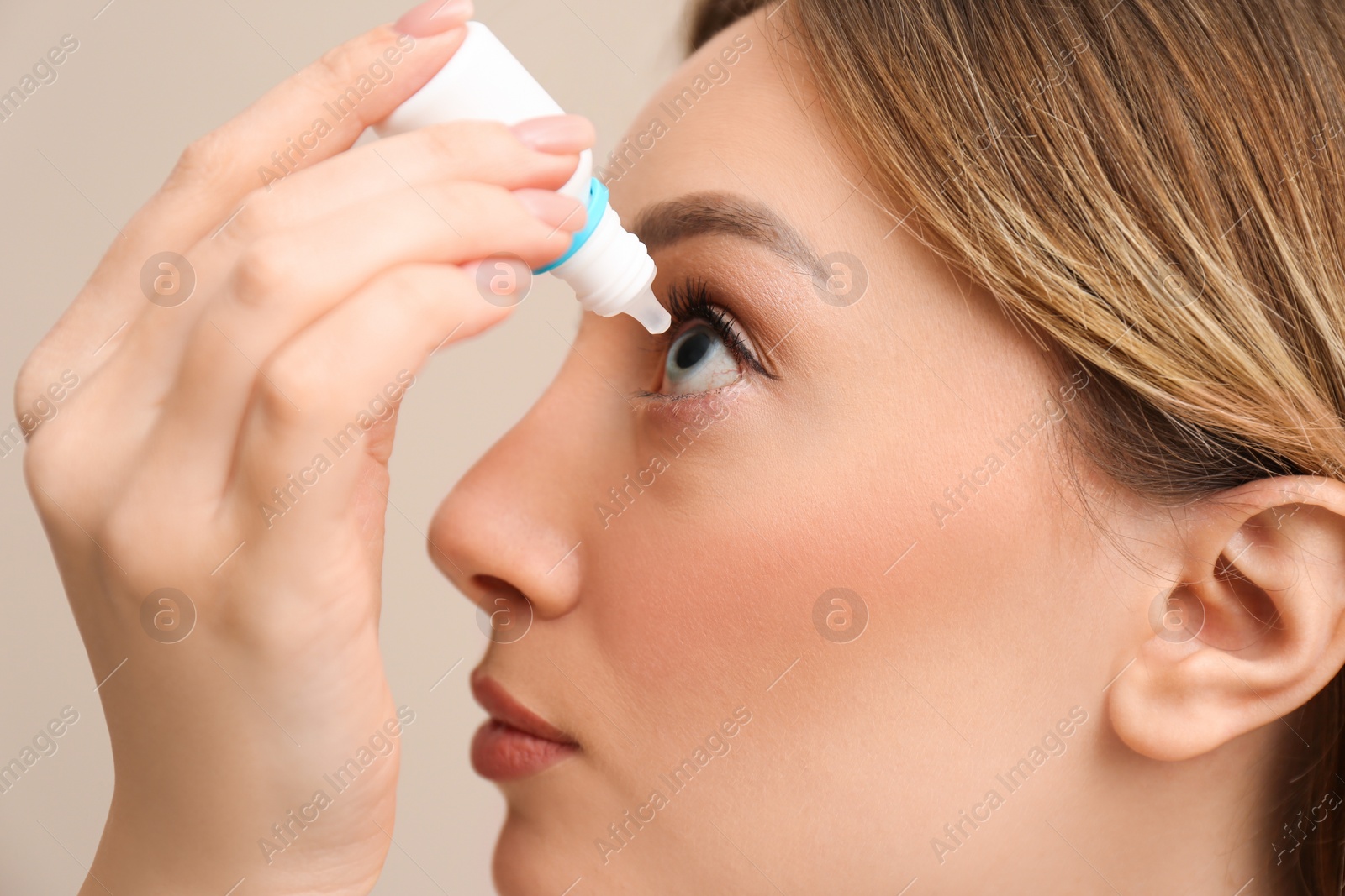 Photo of Young woman using eye drops, closeup view