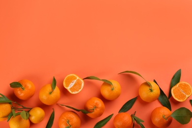 Photo of Fresh tangerines with green leaves on coral background, flat lay. Space for text