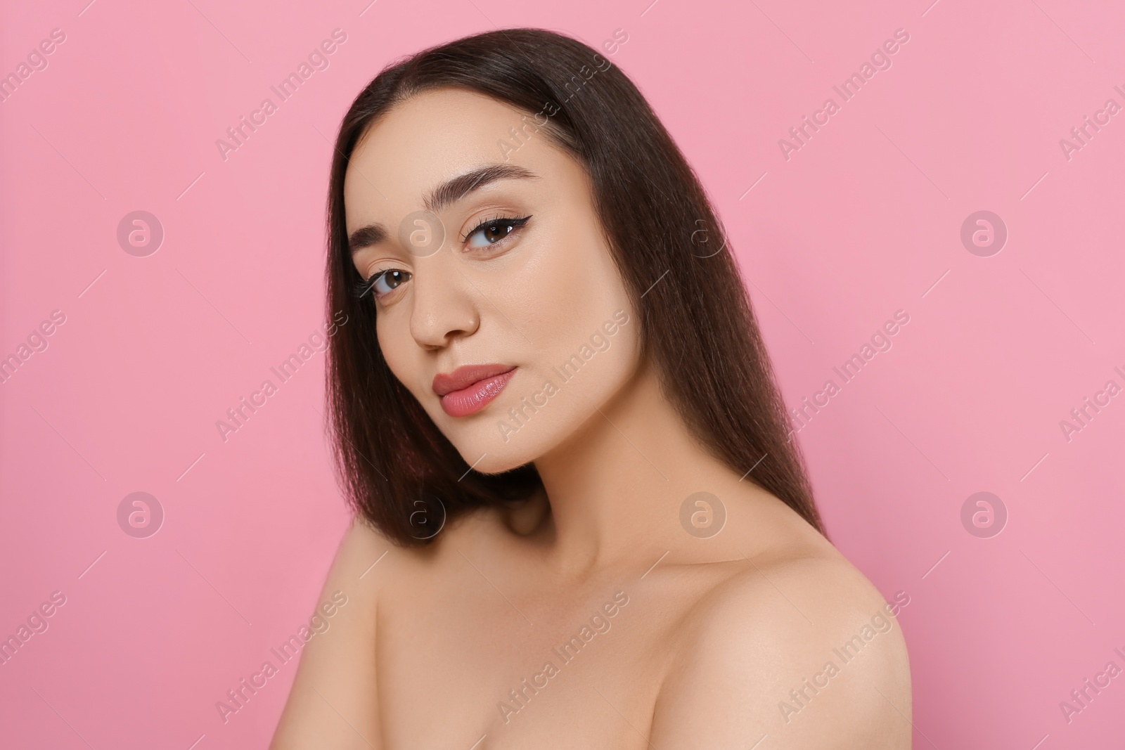 Photo of Portrait of beautiful young woman with elegant makeup on pink background