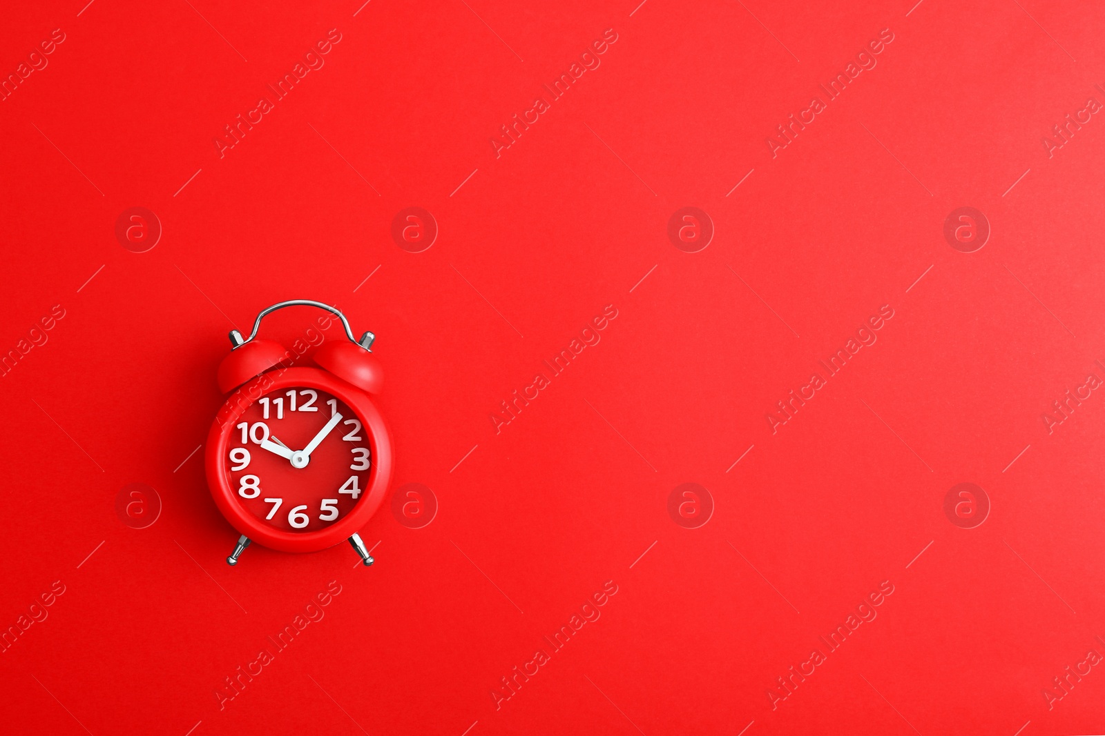 Photo of Modern alarm clock on red background, top view. Space for text