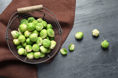 Photo of Basket with fresh Brussels sprouts on table, top view. Space for text