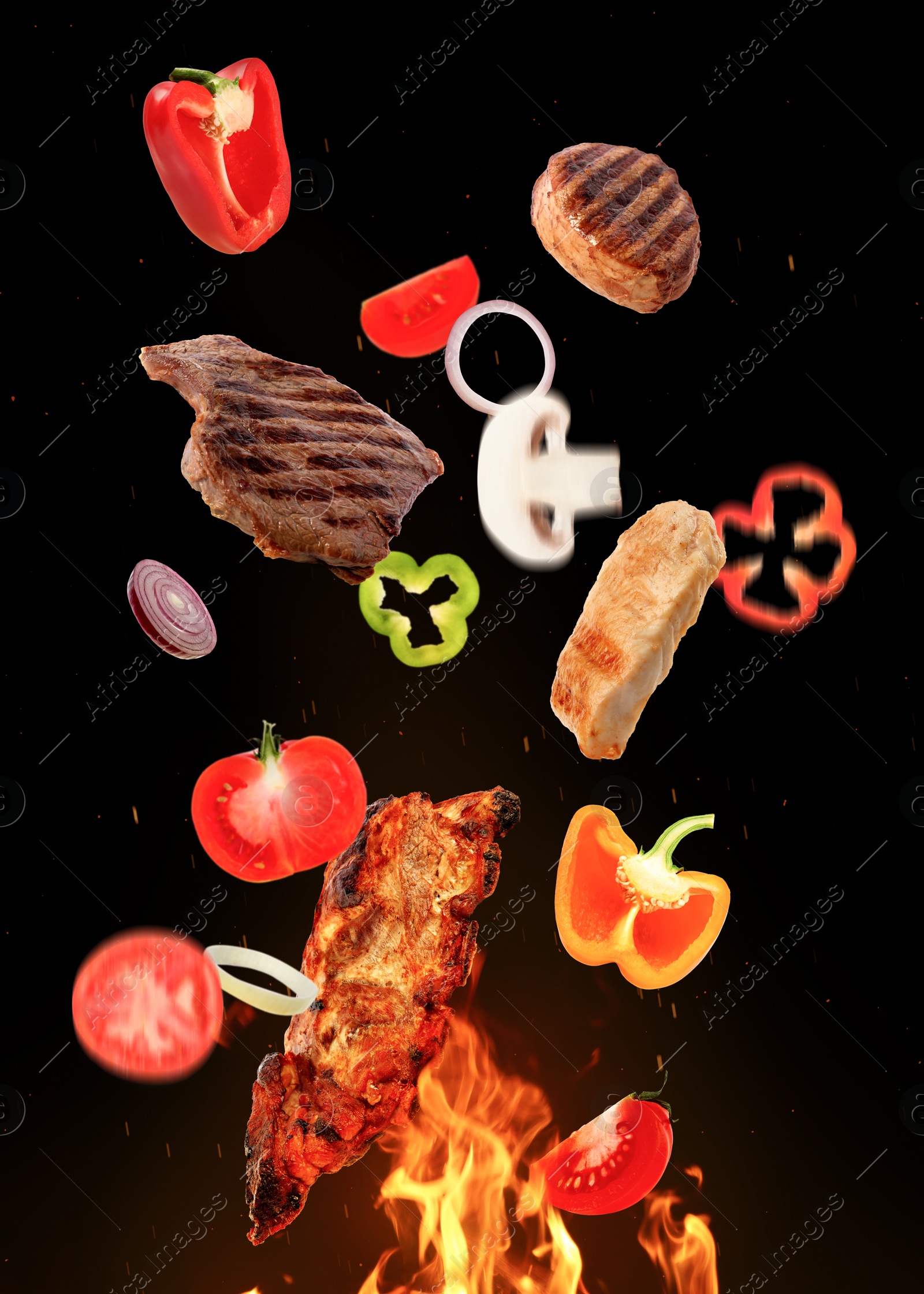 Image of Tasty grilled meat, different vegetables and fire flame on dark background