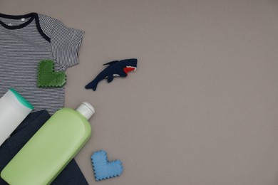 Bottles of laundry detergents, baby clothes, toy shark and decorative hearts on grey background, flat lay. Space for text